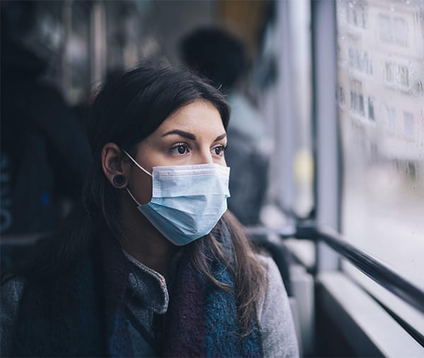 Woman wearing a mask on a bus