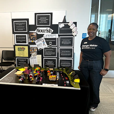 Andrea Thomas standing in front of her table at the 2023 ETS Minnesota Business Accelerator finale