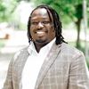 professional headshot of Imokhai Okolo in a park setting