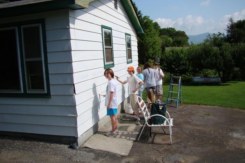 People painting a house at the HInton Center