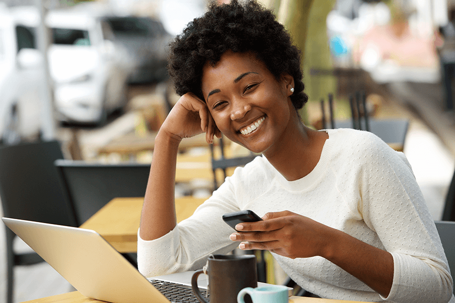 smiling woman at cafe with a mobile phone