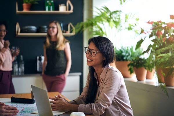 Smiling Asian business woman on a laptop