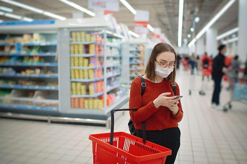 woman shopper reads Heart-Check certified product list while shopping