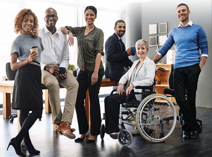 Racially diverse and differently abled persons in the workplace, smiling, posing for camera