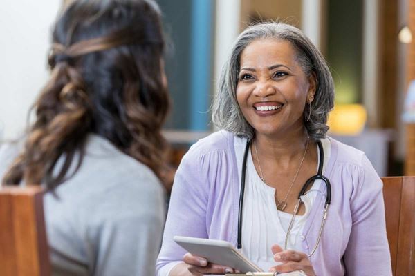 senior medical care worker consulting with woman