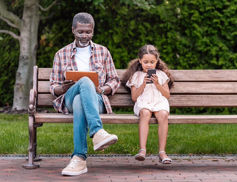 grandfather and child looking at mobile devices