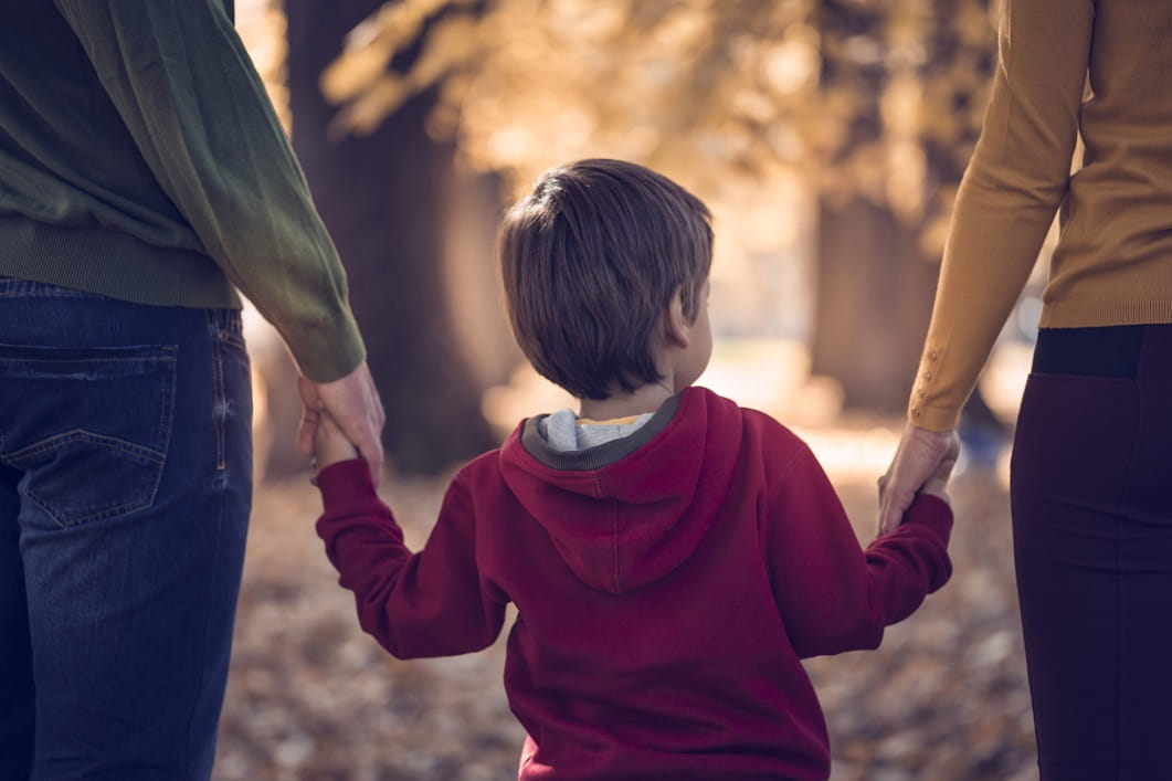 child holding hands with parents