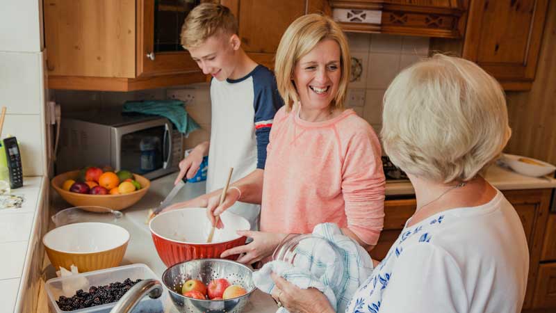 Three generations cooking together in kitchen