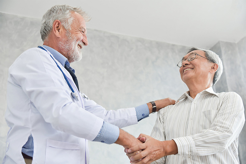 senior doctor shaking hands with patient