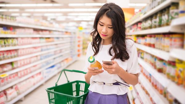 Woman shopper compares price on product on phone Woman shopper compares price on product on phone