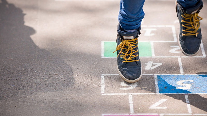 Close-up of a Child's feet playing hop scotch outdoors