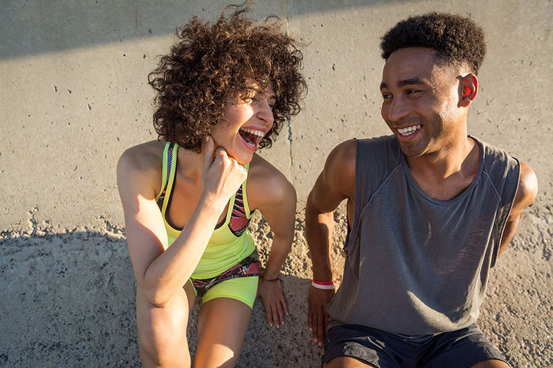 young happy fitness couple in sportswear talking