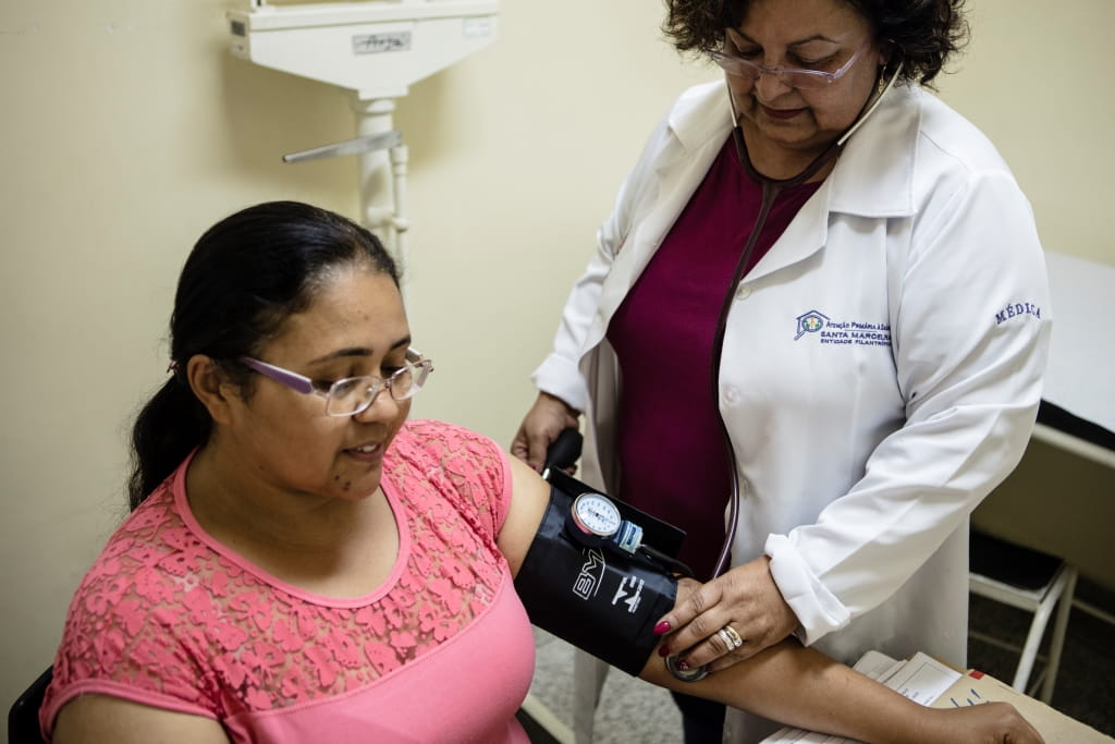 Female doctor taking woman's blood pressure
