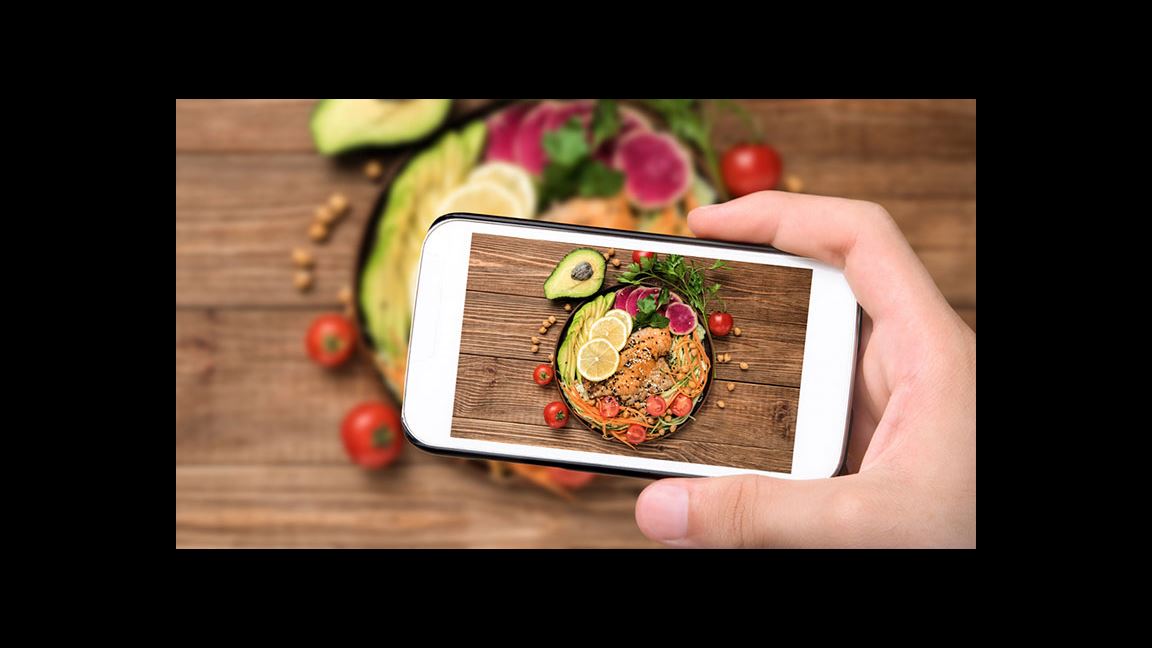 hand taking cell phone picture of healthy fats in salad hand taking cell phone picture of healthy fats in salad