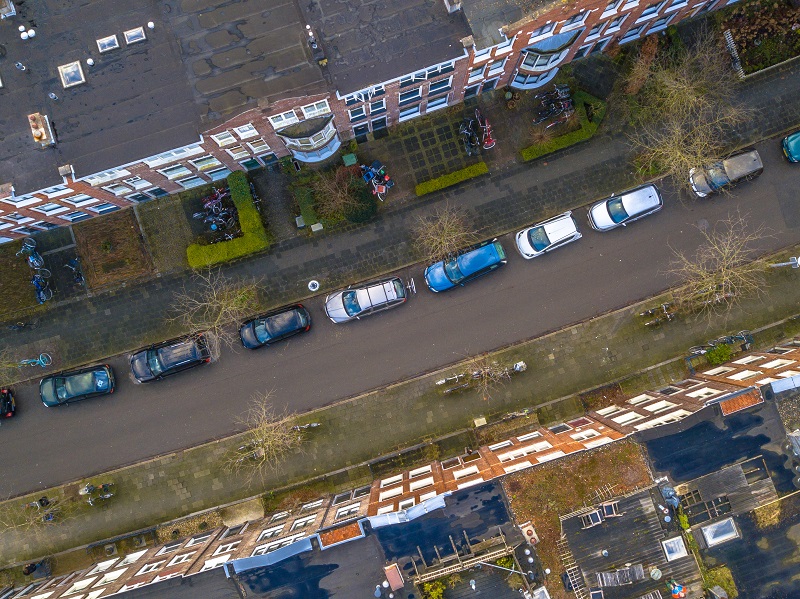 Ariel view of downtown street with housing and cars