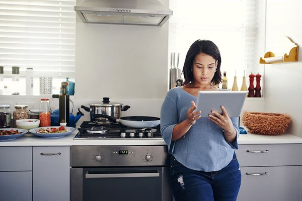 woman using tablet in kitchen woman using tablet in kitchen