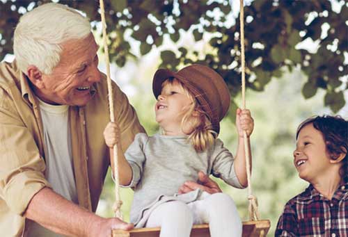 grandpa with grand children on swing