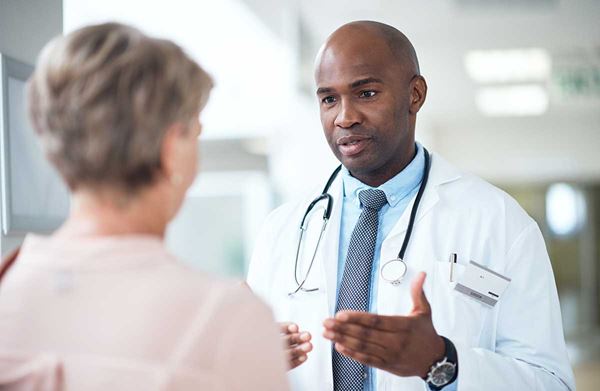 male doctor speaking with female patient