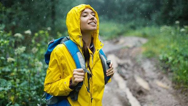 Young woman in raincoat enjoys nature in the rain Young woman in raincoat enjoys nature in the rain