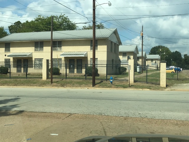 A street view of a gated apartment complex