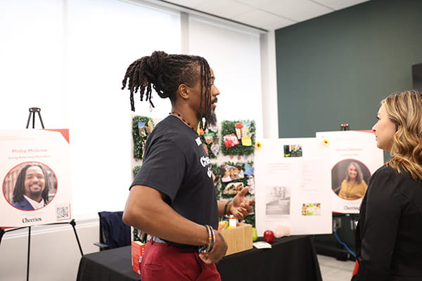 Phillip McGraw is talking with an event guest at his table at the ETS Minnesota Business Accelerator finale