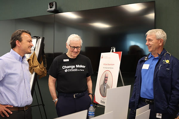 William Swanstrom is talking with event guests at his table at the ETS Minnesota Business Accelerator finale