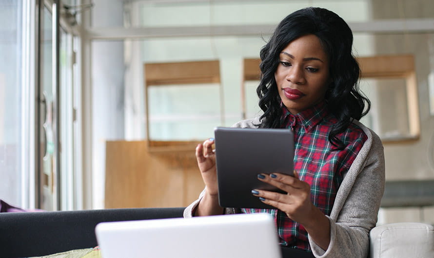 A professional woman is in an office setting interacting with a digital tablet. A professional woman is in an office setting interacting with a digital tablet.