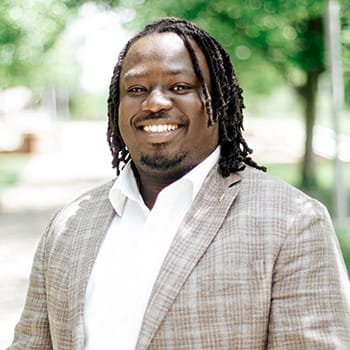 professional headshot of Imokhai Okolo in a park setting