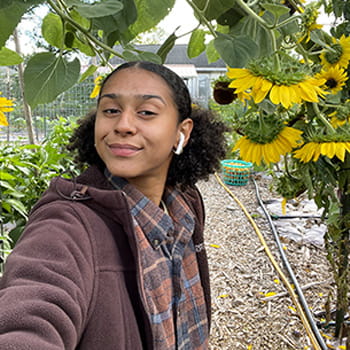 selfie of India Nunn in a garden with sunflowers