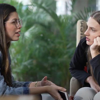 two women having a serious conversation in an outdoor setting