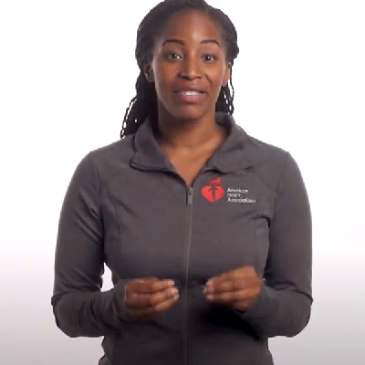 a woman is speaking to the camera against a white background
