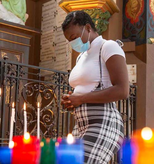 Masked woman standing at the front of a church