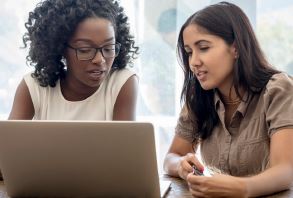 Two young women looking at a laptop