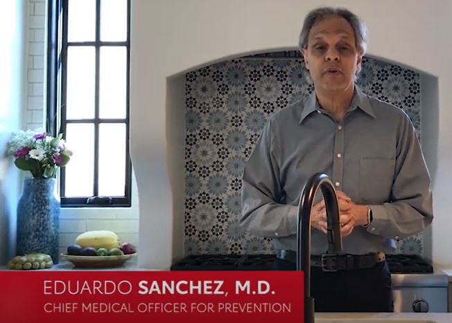 A video frame of Dr. Eduardo Sanchez standing in front of a kitchen sink.