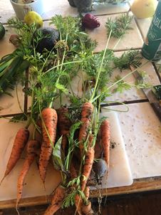 A bunch of freshly-picked, unwashed carrots laying on a cutting board A bunch of freshly-picked, unwashed carrots laying on a cutting board